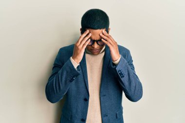 Genç, yakışıklı, İspanyol bir adam. Zarif kıyafetler giyiyor ve kafasında baş ağrısı olan gözlükler takıyor. Stres yüzünden. migren ağrısı. 