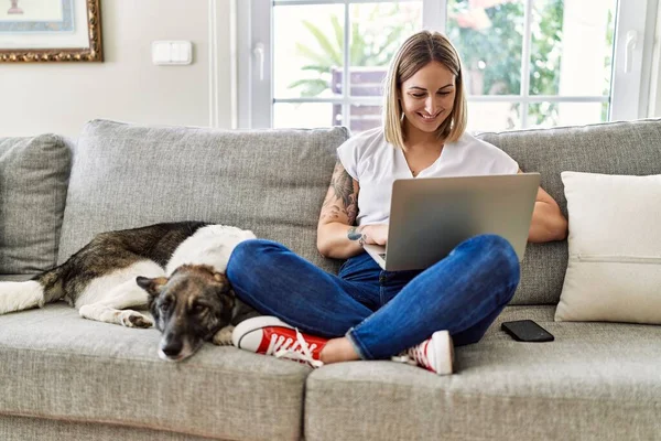 Jovem Caucasiana Sorrindo Feliz Sentado Sofá Com Cão Usando Laptop — Fotografia de Stock