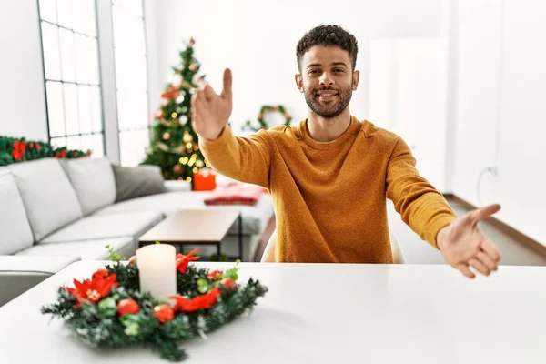 Arab Young Man Sitting Table Christmas Tree Looking Camera Smiling — Stock Photo, Image