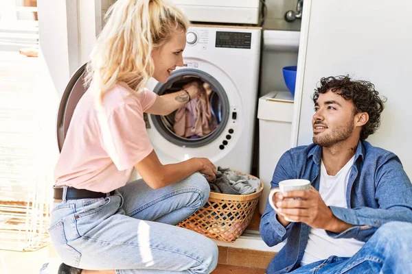 Jovem Casal Sorrindo Feliz Beber Café Enquanto Lavava Roupa Casa — Fotografia de Stock