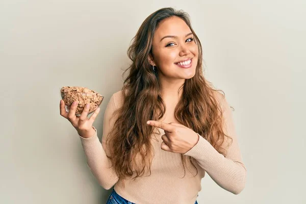 Menina Hispânica Jovem Comer Cereais Integrais Saudáveis Sorrindo Feliz Apontando — Fotografia de Stock
