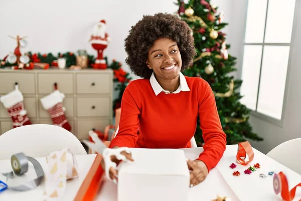 Joven Mujer Afroamericana Sonriendo Confiado Embalaje Regalo Navidad Casa — Foto de Stock