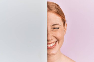 Boş pankart tutan genç İrlandalı kadın kameraya seksi bir ifadeyle bakıyor, neşeli ve mutlu bir yüzle.. 