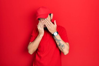 Sakallı İspanyol bir adam teslimat üniforması giyiyor. Yorgunluk ve baş ağrısı için gözlerini ovuşturuyor. Uykulu ve yorgun bir ifade. görme sorunu 