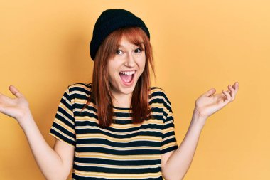 Kızıl saçlı, yün şapkalı genç kadın zaferi mutlu bir gülümsemeyle kutluyor ve kazanan ifade kaldırılmış ellerle. 