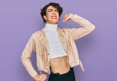 Makyaj yapan yakışıklı bir adam ve kadın giysileri geriliyor, yorgun ve rahat, uykulu ve sabahın erken saatleri için esniyor. 