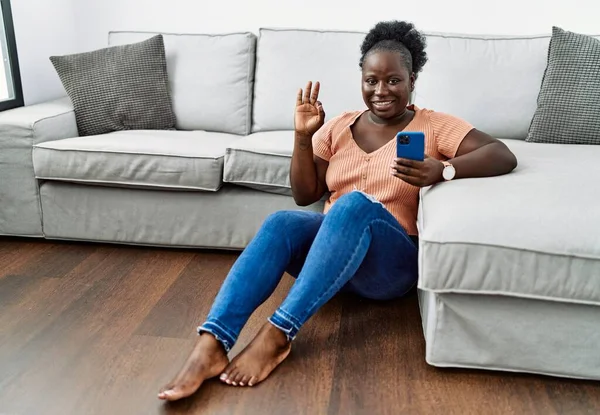 Giovane Donna Africana Utilizzando Smartphone Seduto Sul Pavimento Casa Sorridente — Foto Stock