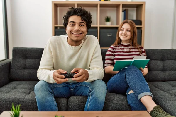 Homem Jogando Videogame Enquanto Namorada Lendo Livro Casa — Fotografia de Stock