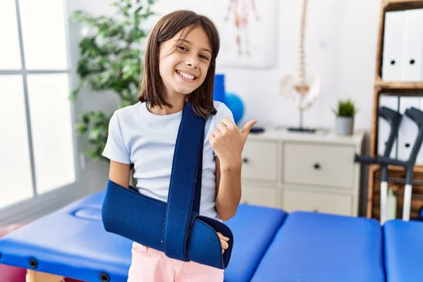 Young Hispanic Girl Wearing Arm Sling Rehabilitation Clinic Smiling Happy — Stock Photo, Image