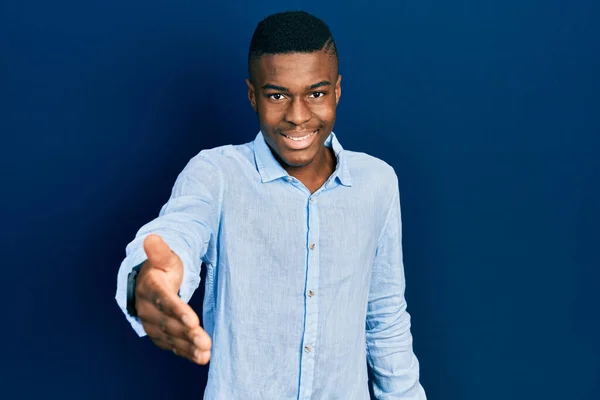 若いアフリカ系アメリカ人の男性は 挨拶や歓迎として握手を提供笑顔カジュアルな服を着ています 成功したビジネス — ストック写真