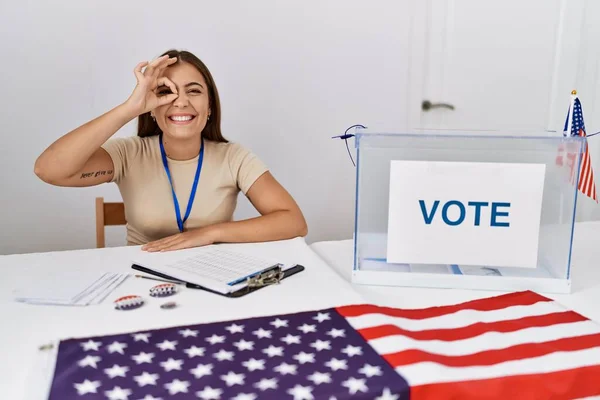 若いですブルネット女性に政治選挙で座っていますによって投票笑顔幸せありますOk Signとともに手で目を通して指を見ます — ストック写真