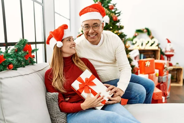 Middle Age Hispanic Couple Holding Christmas Gift Sitting Sofa Home — Stock Photo, Image