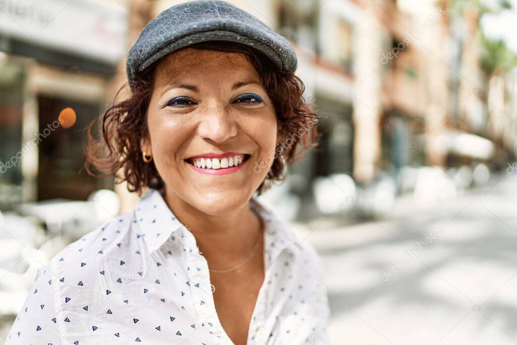 Middle age latin woman smiling happy standing at the city.