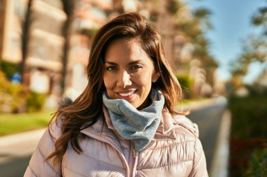 Genç İspanyol kadın gülümseyerek şehirde mutlu mesut dikiliyor..