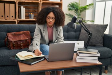 Genç Afrikalı Amerikalı kadın psikolog psikoloji merkezinde dizüstü bilgisayar kullanıyor.