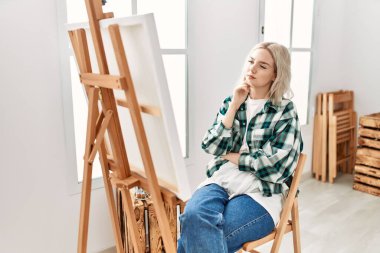 Genç ressam kız resim stüdyosunda tuvale odaklanmış..