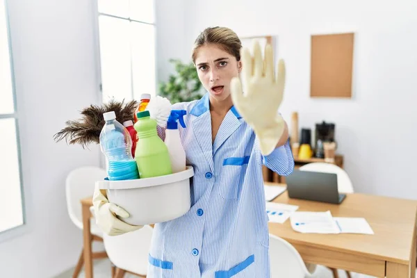 Mujer Rubia Joven Usando Uniforme Más Limpio Sosteniendo Productos Limpieza —  Fotos de Stock