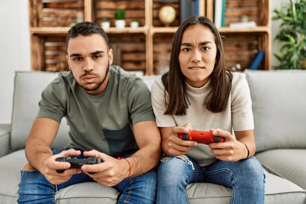 Amigos gamers animados jogando videogame em casa rindo enquanto