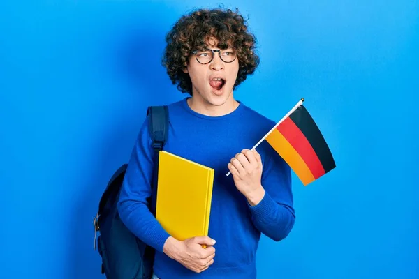 Guapo Joven Estudiante Intercambio Sosteniendo Bandera Alemania Enojado Loco Gritando —  Fotos de Stock