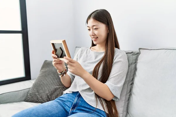 Ung Asiatisk Kvinna Ler Tittar Bilden Vardagsrummet — Stockfoto