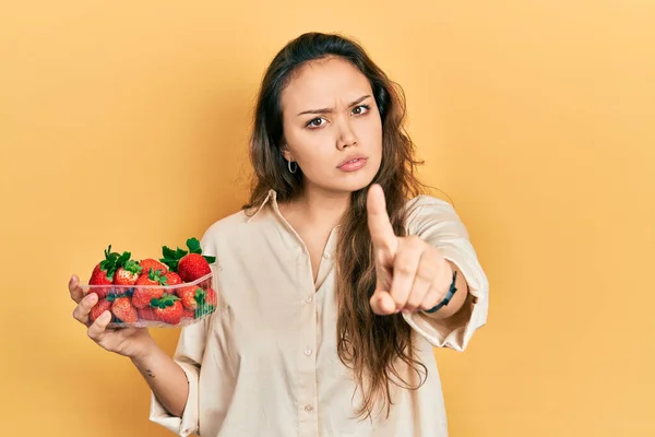 Young Hispanic Girl Holding Strawberries Pointing Finger Angry Expression Showing — Stock Photo, Image