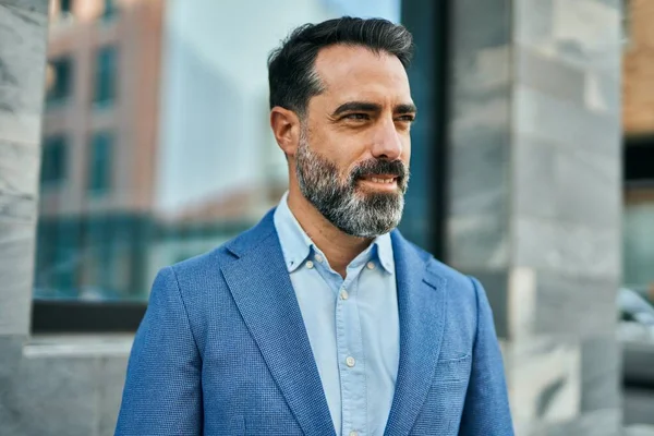 Orta yaşlı işadamı şehirde mutlu mesut dikilirken.