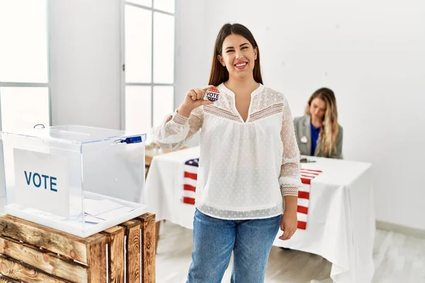 Young american voter woman holding i voted badge standing at electoral college.