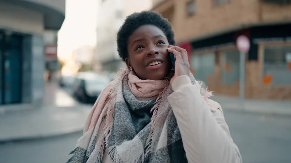 若いアフリカ系アメリカ人の女性が路上でスマートフォンで自信を持って話しています — ストック写真