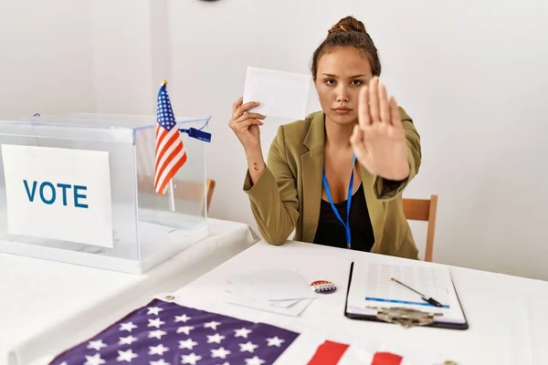 投票箱の中で開いた手で投票を保持する美しいヒスパニック系の女性が真剣に自信を持って式で停止標識を行います 防衛ジェスチャー — ストック写真
