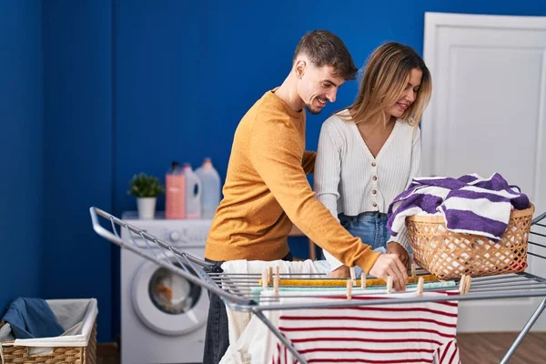 若い男と女カップルハング服上の服で洗濯室 — ストック写真