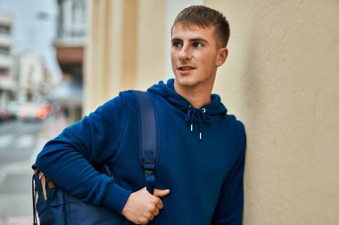 Üniversitede mutlu bir şekilde gülümseyen genç sarışın öğrenci..