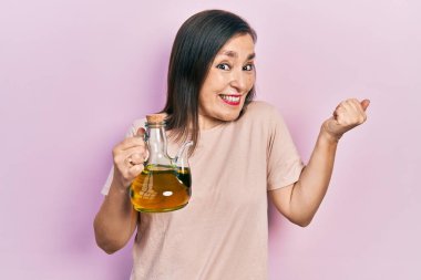 Orta yaşlı İspanyol kadın zeytinyağı tutarken gururla bağırıyor zaferi ve başarıyı kutluyor. 