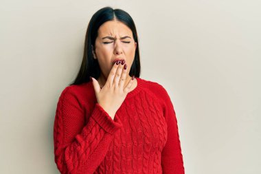 Kışın yün kazak giyen güzel esmer kadın ağzıyla ağzını kapatmaktan sıkılmış. Huzursuz ve uykulu.. 