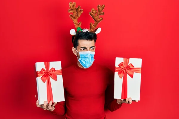 Mladý Hispánec Oblečený Roztomilých Vánočních Rohů Sobů Lékařské Masky Rukou — Stock fotografie
