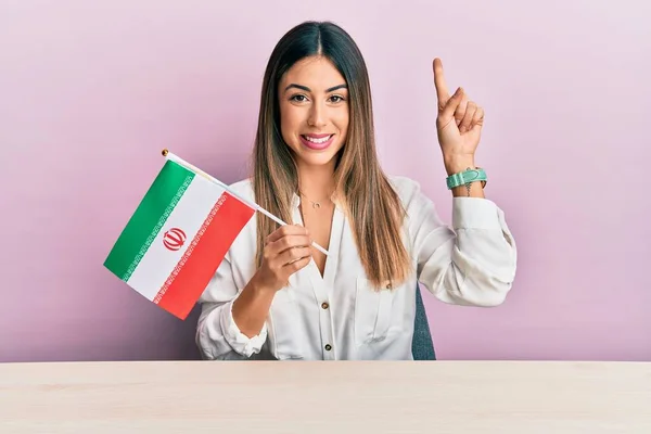 Jovem Hispânica Segurando Bandeira Irã Sentada Mesa Sorrindo Com Uma — Fotografia de Stock