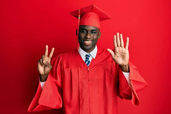 Młody Afroamerykanin Czapce Dyplomowej Szacie Ceremonii Pokazuje Wskazuje Palcami Numer — Zdjęcie stockowe