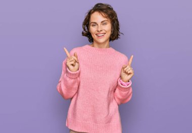 Gündelik giysiler giymiş, kendine güvenen, parmaklarını farklı yönlere çeviren İspanyol bir kadın. reklam için kopyalama alanı 