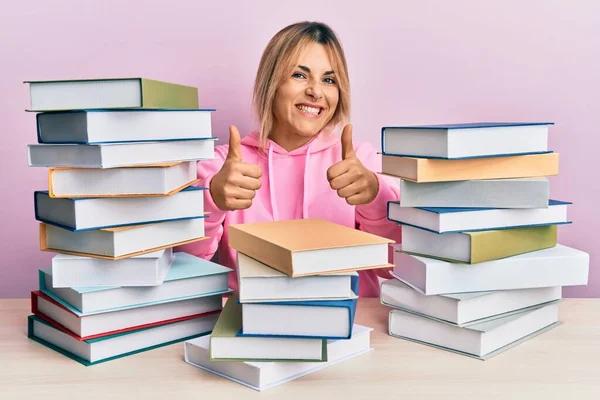 Mujer Caucásica Joven Sentada Mesa Con Libros Aprobando Hacer Gesto — Foto de Stock