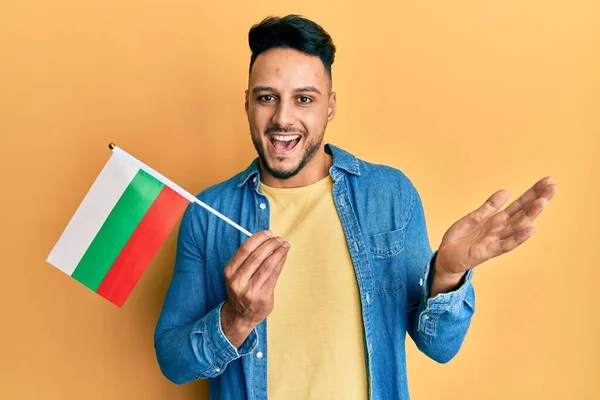 Mladý Arabský Muž Držící Bulharskou Vlajku Slaví Úspěch Šťastným Úsměvem — Stock fotografie
