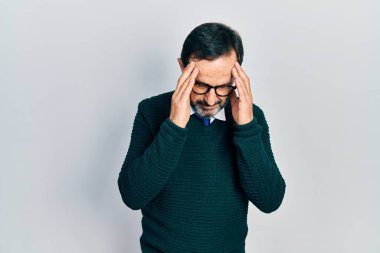Orta yaşlı İspanyol bir adam günlük kıyafetler giyiyor ve stres yüzünden başı ağrıyan bir gözlük takıyor. migren ağrısı. 