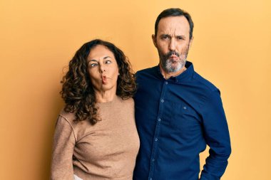 Orta yaşlı İspanyol çift gündelik kıyafetler giyip dudaklarıyla balık suratı yapıyor, çılgınca ve komik bir jest. Komik ifade. 