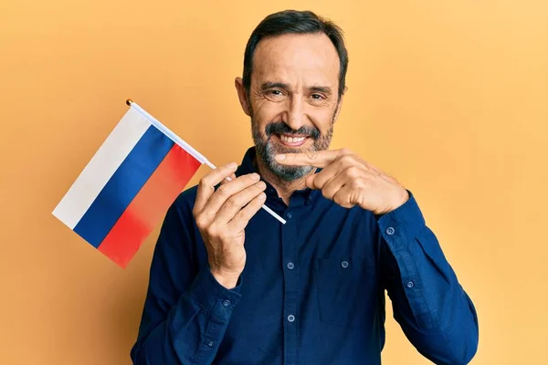 중년의 야만인 러시아 국기를 손가락으로 행복하게 가리키며 — 스톡 사진