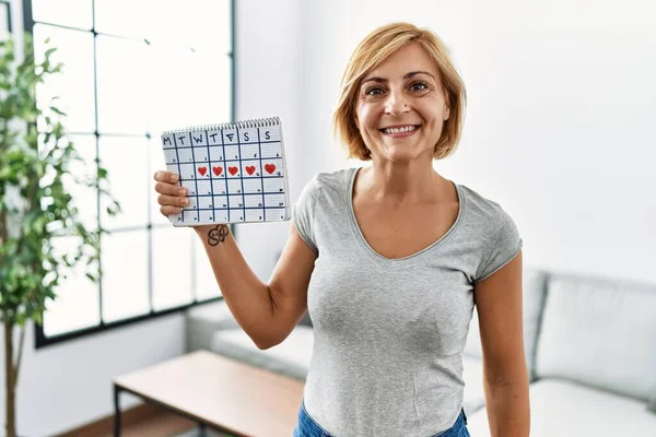 Middle Age Blonde Woman Holding Heart Calendar Looking Positive Happy — Stock Photo, Image