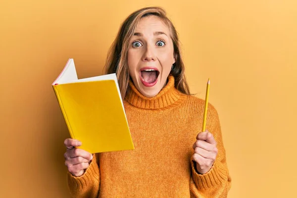 Genç Sarışın Kadın Elinde Kitap Kalemle Çılgınlığı Kutluyor Başarıya Hayret — Stok fotoğraf