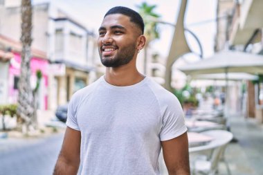 Orta Doğu 'lu genç adam gülümsüyor. Mutlu bir şekilde şehirde duruyor..