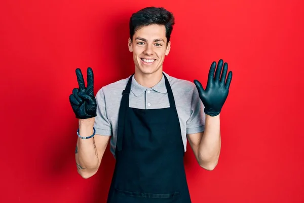 Young Hispanic Man Wearing Apron Showing Pointing Fingers Number Seven — Stock Photo, Image