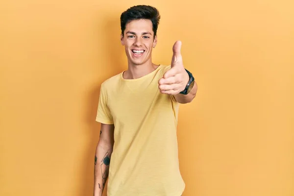 Jovem Hispânico Vestindo Casual Camiseta Amarela Sorrindo Amigável Oferecendo Aperto — Fotografia de Stock