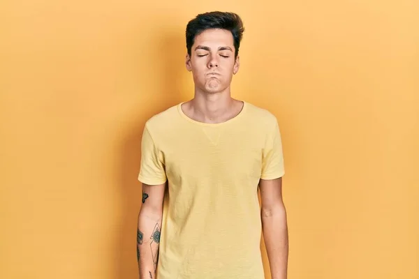 Joven Hombre Hispano Con Una Camiseta Amarilla Casual Hinchando Mejillas — Foto de Stock