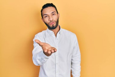 Sakallı, iş gömleği giymiş İspanyol bir adam kameraya bakıyor ve havada bir öpücük savuruyor. Güzel ve seksi. aşk ifadesi. 