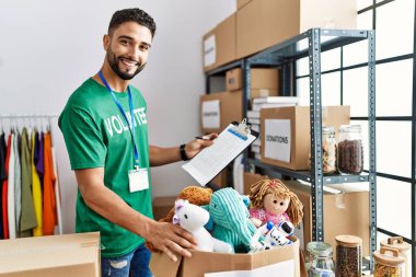 Gönüllü üniformalı genç bir Arap hayır kurumunda çalışıyor.